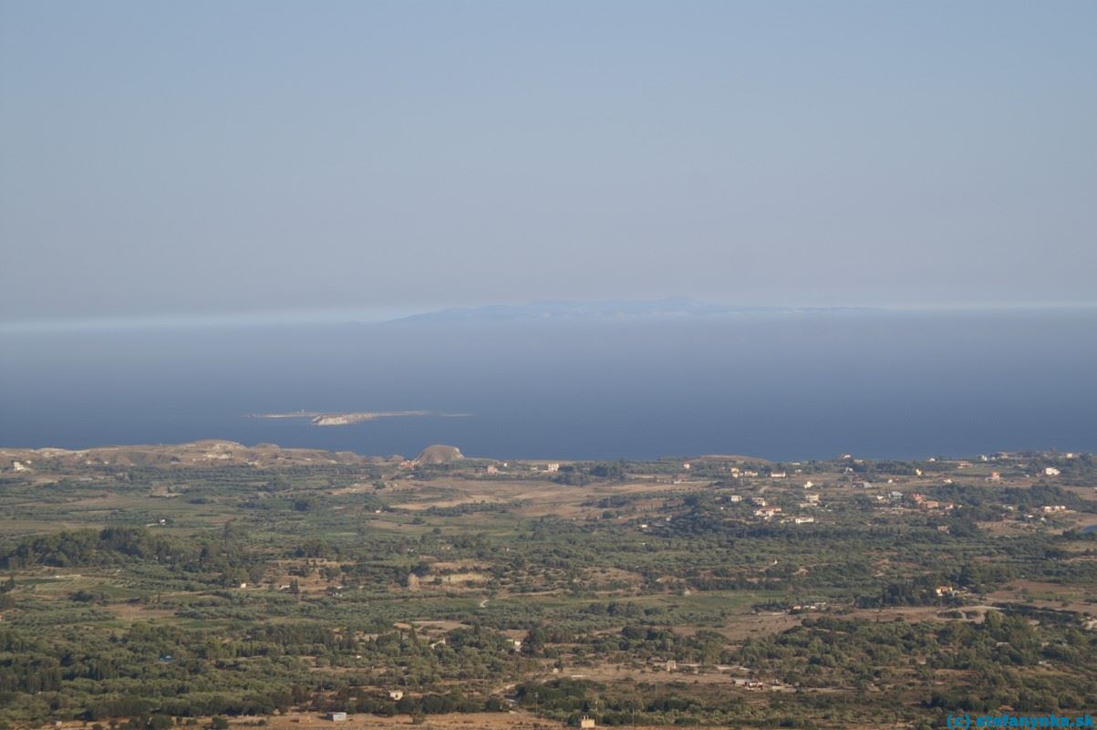 Kefalónia. Pohľad na južnú časť poloostrova Paliki. Ostrovček pri pobreží ležal oproti pláži Xi. Ostrov v pozadí je Zakyntos