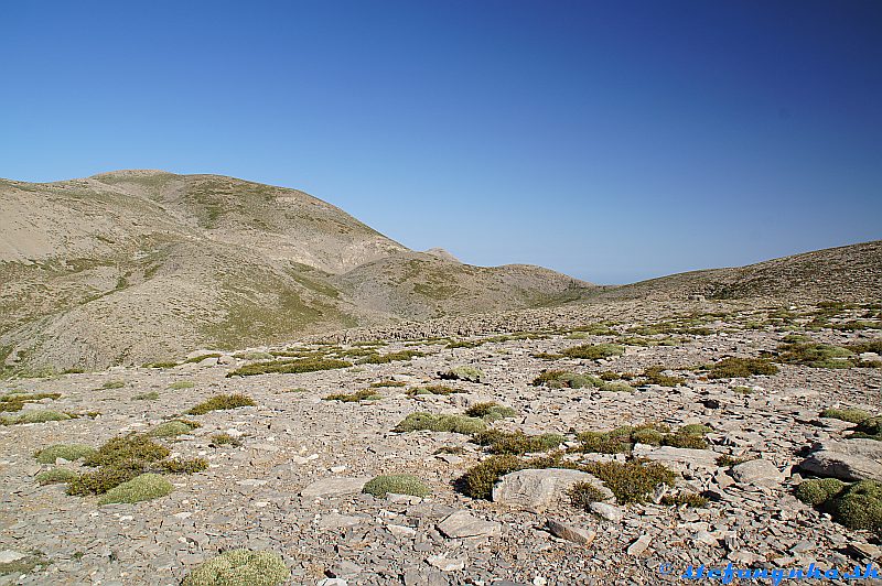 Pri Mitate. Psiloritis je vzadu v tých najvyšších kopcoch. Približne v strede obrázka je trojuholníková Stolistra a vpravo od nej je sedlo Seli.Od neho vedie šikmo doľava dolu chodník k rázcestiu Seli
