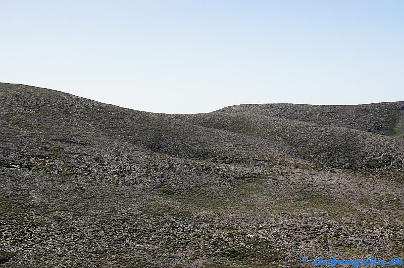 Výstup na Psiloritis. Pohľad spod sedla Seli na Mitatu (čierna machuľa vpravo od sedla) a chodník vedúci k rázcestiu Seli (vpravo dole mimo obraz)