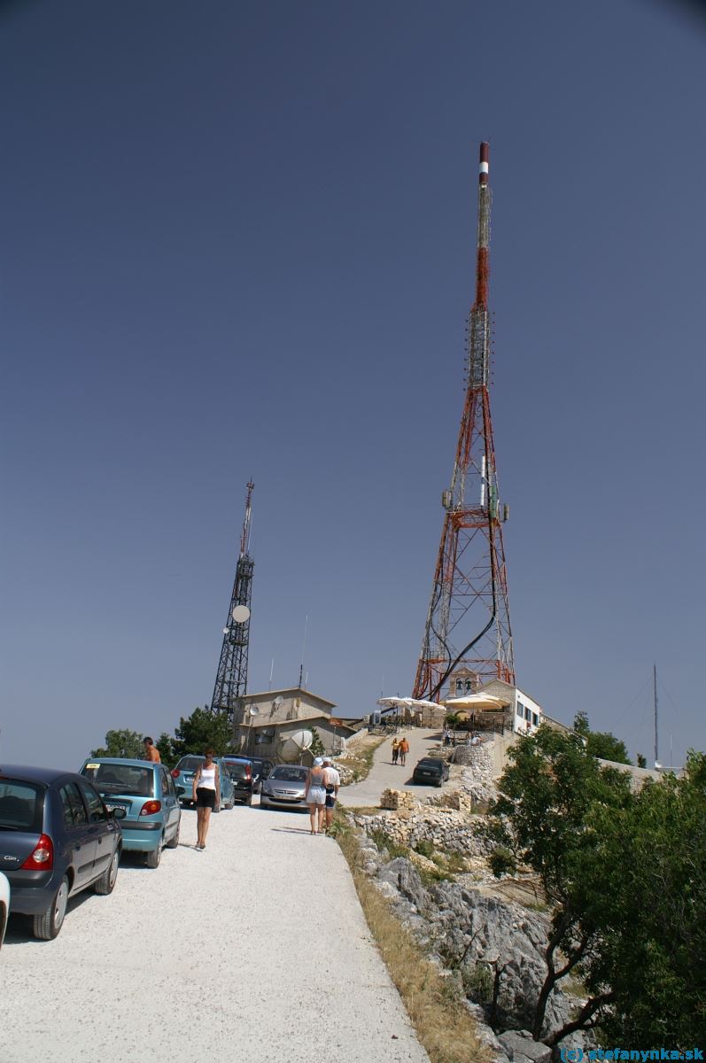 Korfu, Pantokrator. Vysielače na vrchu Pantokrator na severe Korfu. Pohľad od zákruty. Parkovanie aut zväčša na ceste.