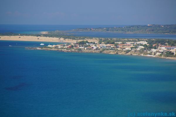 Stredisko Agios Georgios south, zvané aj Argirades. Sprava centrum obce a severná pláž (na úrovni bielej loďky je hotel Aquis sandy Resort, za loďkou je pláž Issos a duny - dnes zarastené pichľavými stromami).