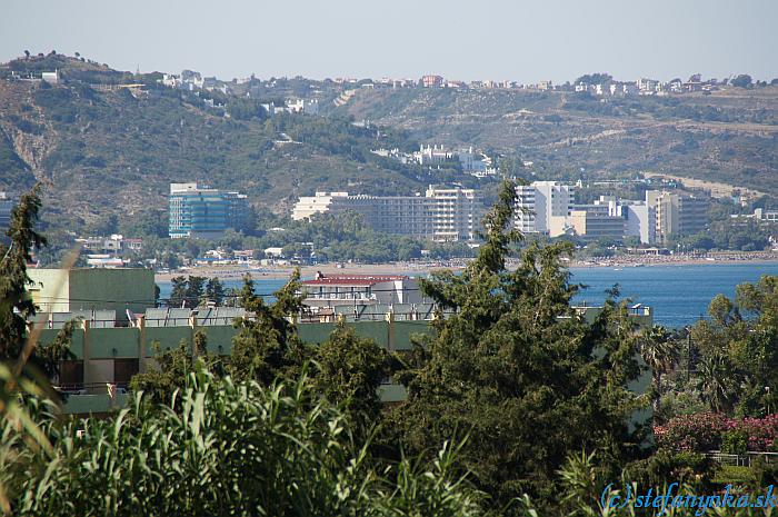 Pohľad na Pegasos Beach (vpravo od modrého hotela). Kopec vľavo je Agia Sofia a vpravo nad posledným vysokým hotelom je vidno trochu z modého tobogánu v Aquaparku