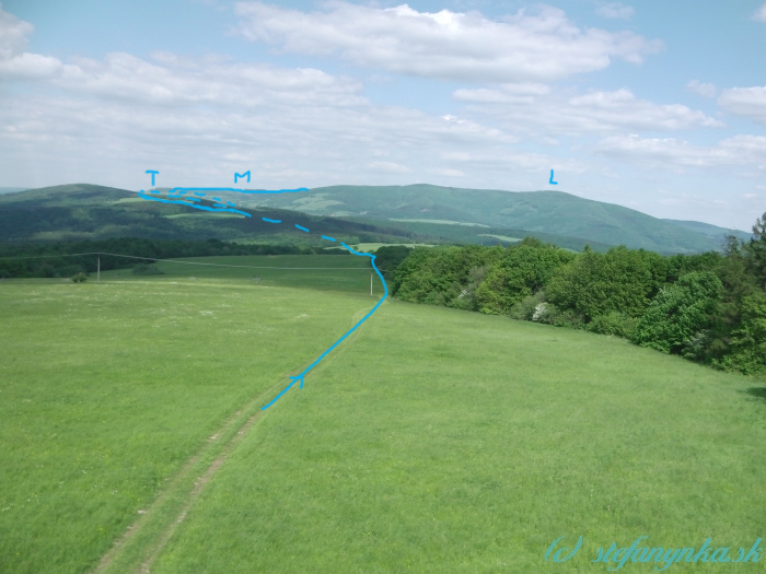 Pohľad naspäť z rozhľadne Obecnice. V ľavej tretine fotky sa nachádza takmer celá časť cesty cez Troják (T) až po Mikulčin vrch (M). V strede Malý Lopeník a doprava po hrebeni na Veľký Lopeník (L)